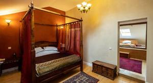 a bedroom with a canopy bed and a mirror at Hotel Regal 1880 - Boutique Hotel in Parcul Central Sinaia in Sinaia
