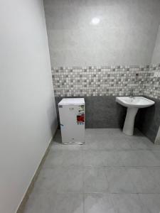 a bathroom with a sink and a small refrigerator at شقق الشموخ in Dammam