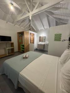 a bedroom with a bed with two slippers on it at Zion in Capesterre