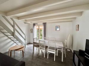a dining room with a white table and chairs at Maison avec plage à pied in Saint-Georges-dʼOléron