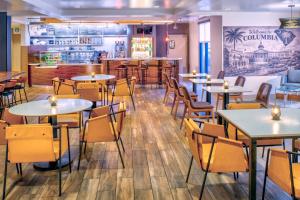 a restaurant with tables and chairs and a bar at Courtyard by Marriott Columbia Northeast/Fort Jackson Area in Killian