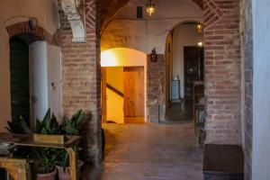 a hallway with a brick wall and a yellow door at Il pozzo & La volta in Siena