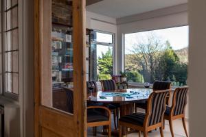a dining room with a table and chairs and a window at Windlestraw Guesthouse in Walkerburn
