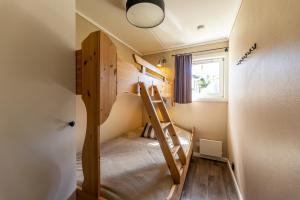 a small room with a bunk bed and a ladder at Gula Byn 410 in Sälen