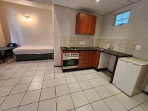 a kitchen with a sink and a stove and a refrigerator at Ben's Place in Pretoria