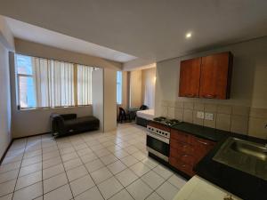 a kitchen with a sink and a stove top oven at Ben's Place in Pretoria