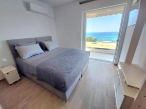 a bedroom with a bed with a view of the ocean at Saroné Villa in Anavyssos