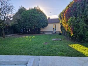 a yard with a house with a hedge and trees at Residence Chateau d Eau in Mitry-Mory
