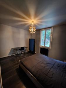 a bedroom with a bed and a table and a chandelier at Residence Chateau d Eau in Mitry-Mory