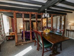 a dining room with a table and a mirror at Penlone Cottage in Rhayader