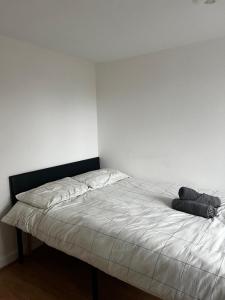 a bed in a room with a white wall at Overton 1 in London +2 photos