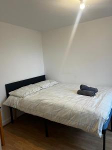a bed in a room with a white wall at Overton 1 in London