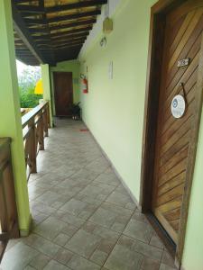 a hallway with a wooden door and a tile floor at Condomínio Pousada Amarela 100 metros da Praia in Iguaba Grande +18 photos