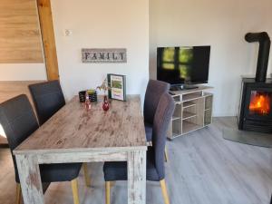 a living room with a wooden table and a tv at Sonniges Sundchalet in Stralsund