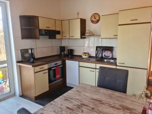 a small kitchen with white appliances and a table at Sonniges Sundchalet in Stralsund
