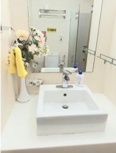 a bathroom with a white sink and a mirror at Shirley Pico de Loro 1BR in Nasugbu +20 photos