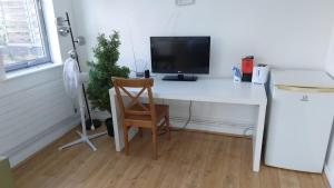 a white desk with a television and a chair at Newbury 2 in London