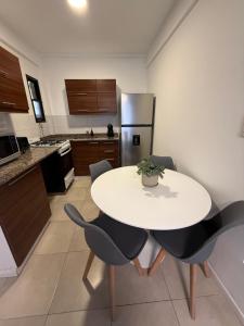 a kitchen with a table and chairs and a refrigerator at Work & Stay Zarate in Zárate