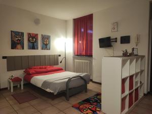 a bedroom with a bed with red pillows and a television at Leo House in Trezzo sullʼAdda