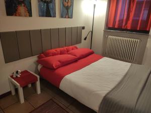 a bedroom with a bed with red pillows and a lamp at Leo House in Trezzo sullʼAdda