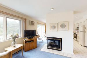 a living room with a fireplace and a tv at Mountainside Resort: K105 in Stowe