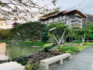 a building with a bench in front of a river at Shirley Pico de Loro 1BR in Nasugbu