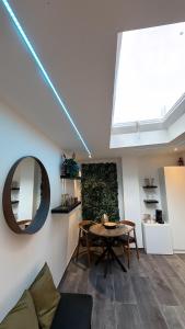 a living room with a table and a mirror at Charnel - Suite Bali in Liège
