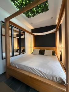 a bedroom with a wooden bed with a window at Charnel - Suite Bali in Liège