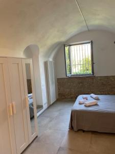 a bedroom with a bed and a window and a mirror at Il pozzo & La volta in Siena