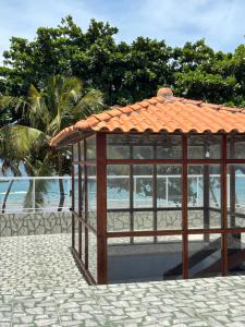 a gazebo with an orange roof on a beach at Hannah House in Marechal Deodoro