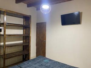 a bedroom with a bed and a tv on the wall at Departamentos la lucia in Villa Paula de Sarmiento