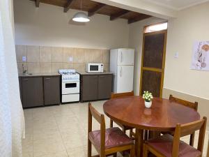 a kitchen with a wooden table and a table and chairs at Departamentos la lucia in Villa Paula de Sarmiento +3 photos