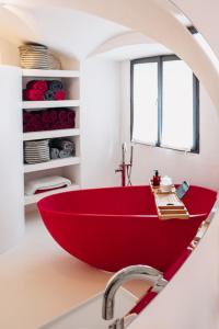 a red bath tub in a bathroom with a mirror at Brána historic Boutique Apartments in Horažďovice