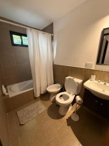 a bathroom with a toilet and a sink and a tub at Work & Stay Zarate in Zárate