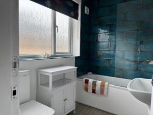 a bathroom with a sink and a tub and a toilet at Palm Tree House in Filey +20 photos