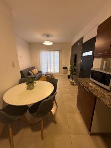 a kitchen and living room with a table and a couch at Work & Stay Zarate in Zárate