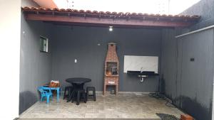 a patio with a table and chairs and a television at SSP Ubajara in Ubajara