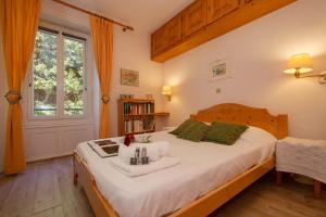 a bedroom with a bed with white sheets and green pillows at Résidence Bel'Alp in Chamonix