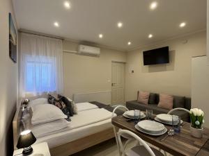 a bedroom with a bed and a dining table at Milano Vendégház in Bakonybél