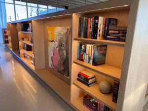 a library with wooden shelves filled with books at Luxe Apartment with Harbor views in Baltimore