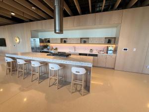 a large kitchen with a large island with bar stools at Luxe Apartment with Harbor views in Baltimore +24 photos