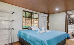 a bedroom with a blue bed with towels on it at Sloth House Rio Celeste in Rio Celeste
