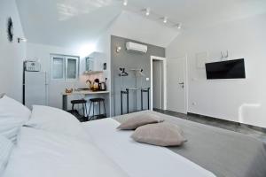 a white bedroom with a bed with pillows on it at Core of Hvar Old Town in Hvar +39 photos