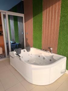 a white tub in a room with a green wall at برج داماك الجوهرة جدة - Damac Al Jawharah Tower in Jeddah +22 photos