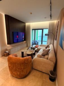a living room with a couch and a tv at برج داماك الجوهرة جدة - Damac Al Jawharah Tower in Jeddah