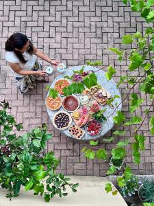 a woman sitting at a table with food on it at Agriturismo Alveare in Finale Ligure