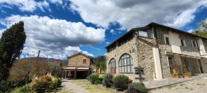 a large stone building with a blue sky and clouds at Agripodere il Falco - Tuscany Nature & Relax in Pontremoli