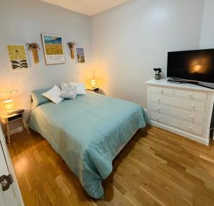 a bedroom with a bed and a dresser with a television at Apto Tramontana 98 in El Puerto de Santa María