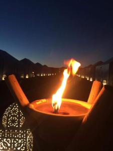 a fire in a table with two chairs at night at Chez zakaria guest in Erfoud