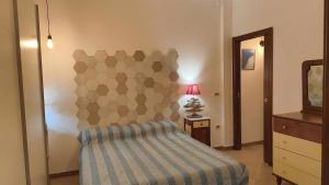 a bedroom with a bed and a dresser and a mirror at CRema Beach in Palmi